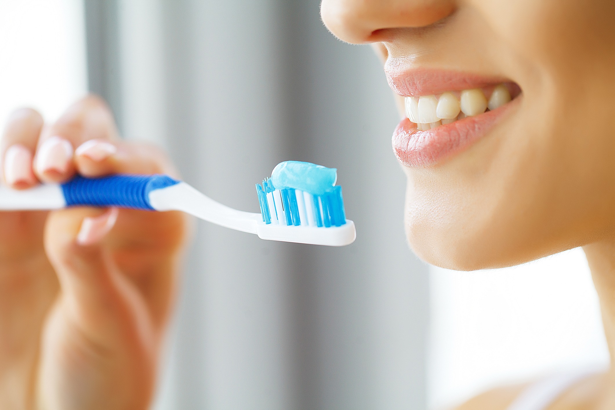 Woman brushing and flossing her teeth